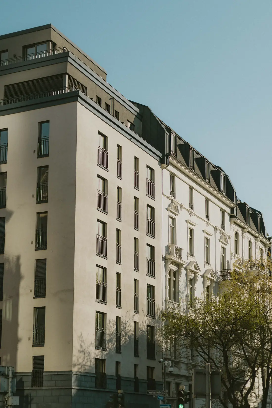 Moderner und historischer Wohnblock nebeneinander in einer Straßenzeile